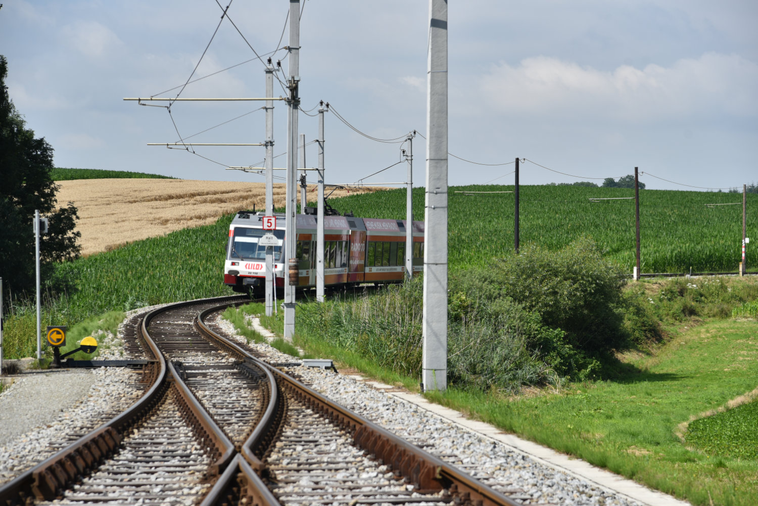 Eine Lilo fährt auf Schienen durch das Land